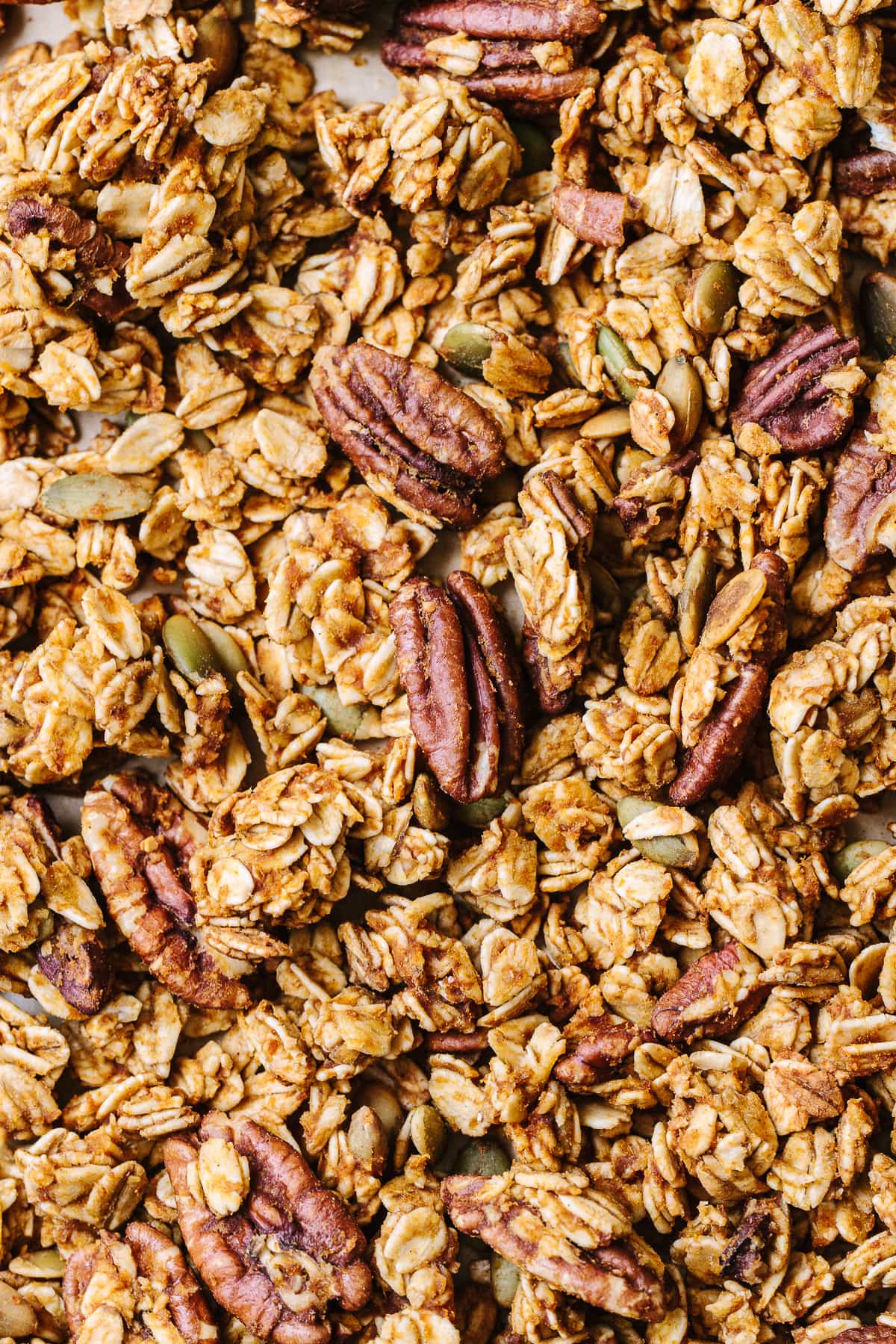 top down view of freshly made healthy pumpkin granola on a baking sheet.