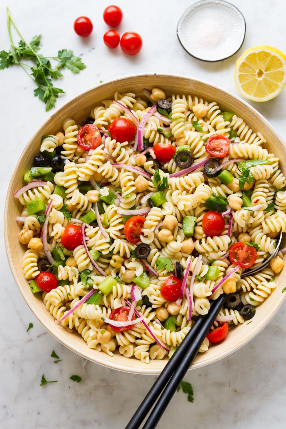 top down view of freshly mixed easy vegan pasta salad in a large serving bowl.