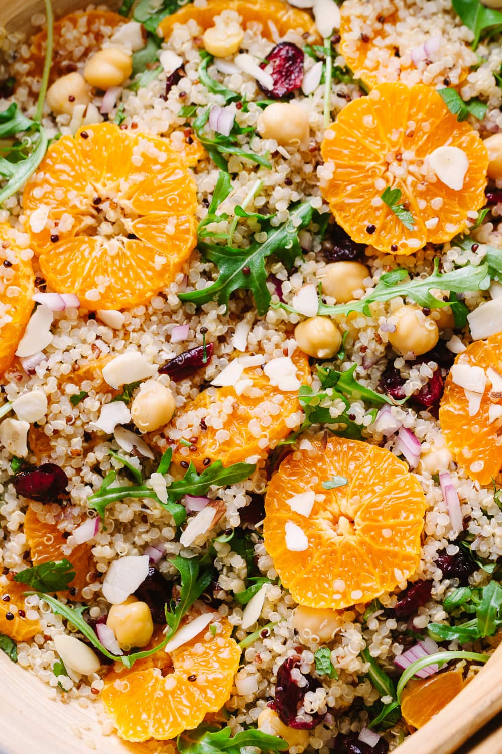 close up, top down view of quinoa salad with orange, cranberry and mint freshly tossed and ready to serve.