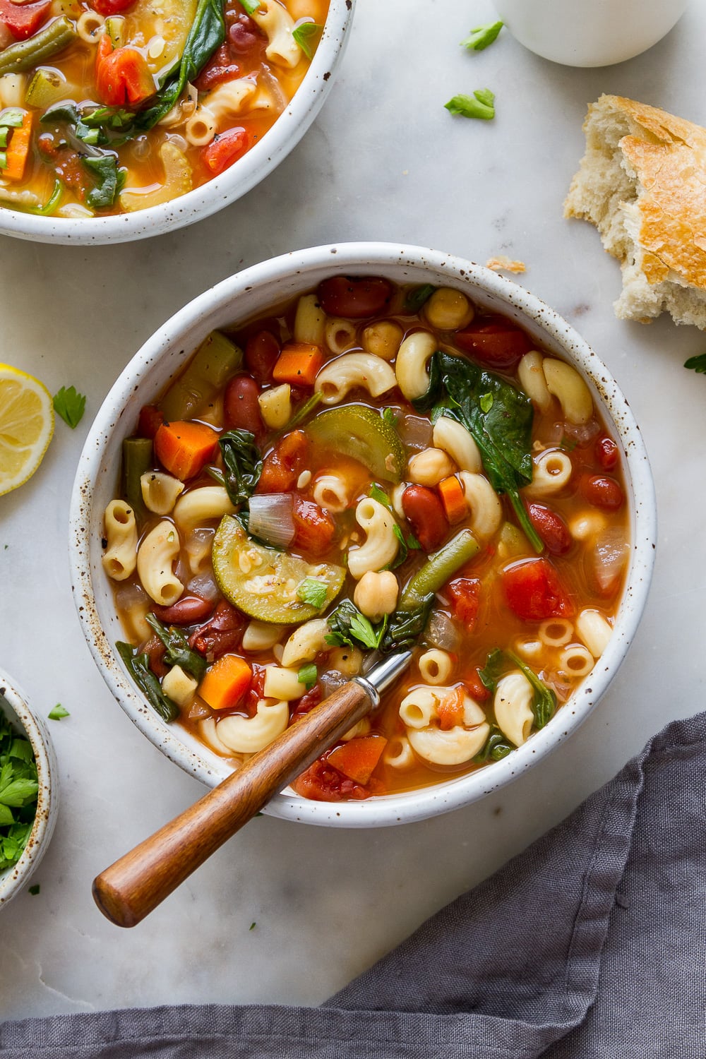 top down view of a bowl full of freshly made easy vegan minestrone with wooden spoon.